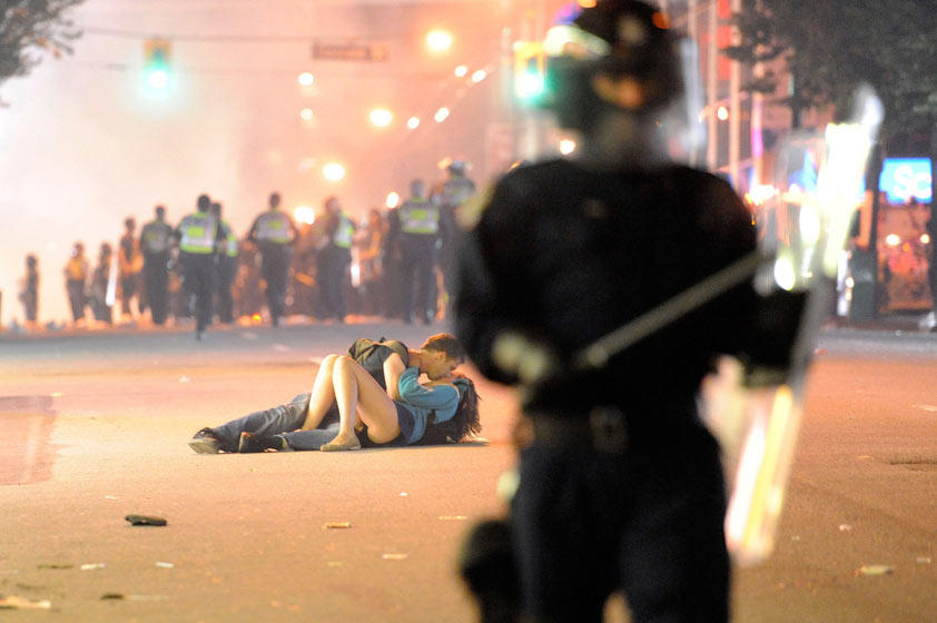Couple kissing during riot full size