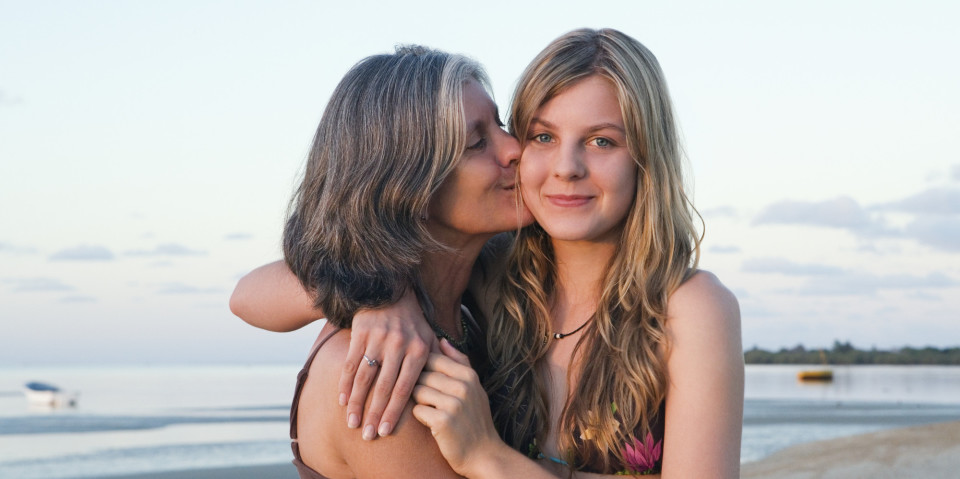 Mother hugging teen daughter full size
